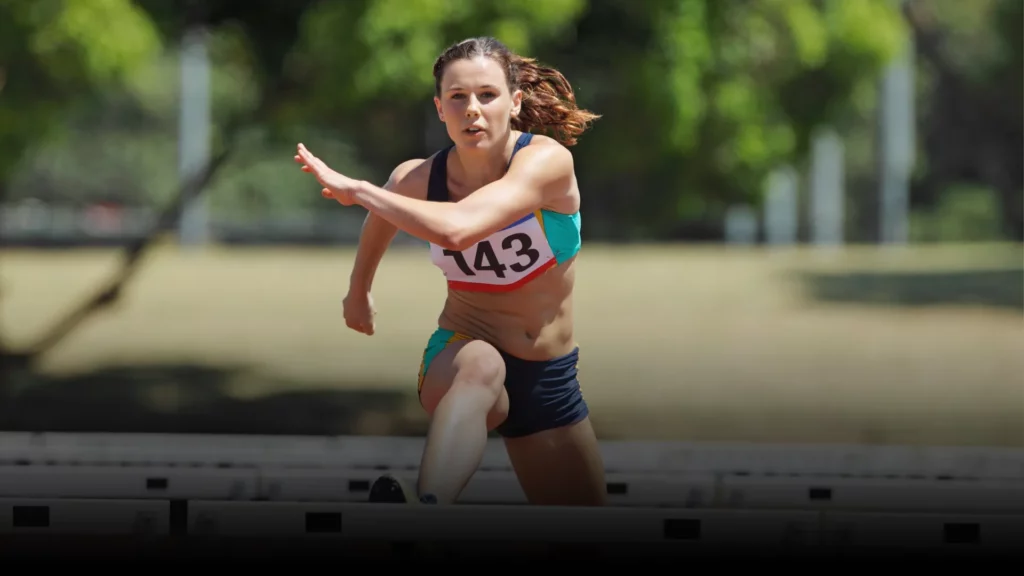 Leichtathletin sprintet konzentriert und mental topfit auf der Laufbahn.