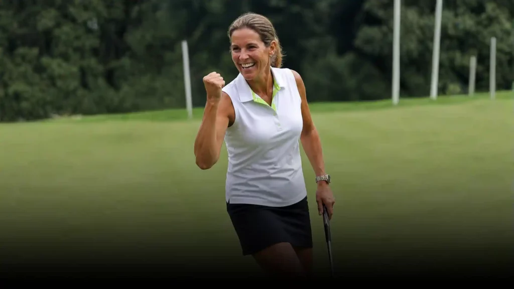 Golfspielerin in Gewinnerpose auf Green.